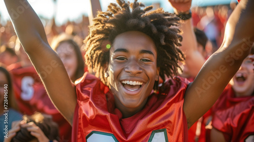 Joyful Teen Football Player Celebrating Victory at Sunset photo