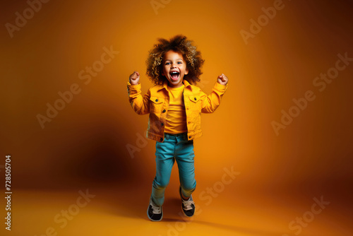 Happy baby laughing and jumping up on a yellow background
