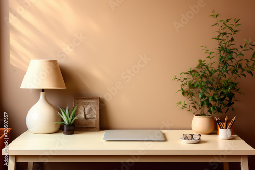 Home workplace with laptop, desk lamp, writing utensils and potted plants © Sunshine