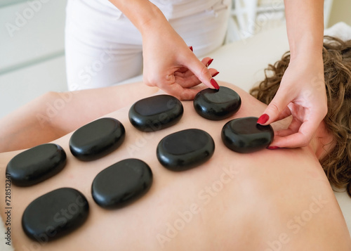Massage with black stones on the back
