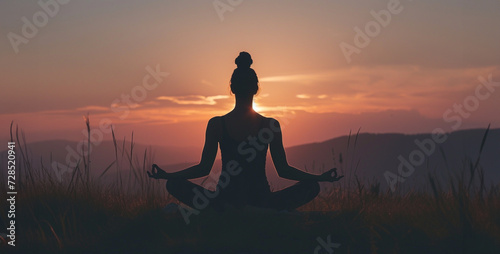 Yoga woman in lotus pose on top of mountain at sunset,Silhouette of woman practicing yoga in the lotus position at sunset