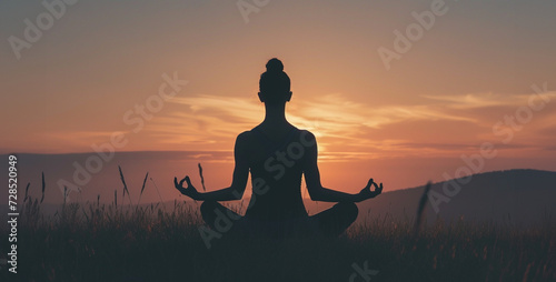 Yoga woman in lotus pose on top of mountain at sunset Silhouette of woman practicing yoga in the lotus position at sunset