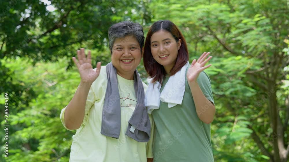 Attractive Senior mother and daughter working out together in the morning exercise in the park. Daughter absorbs sweat from her mom with white towel, a senior caregiver, and a happy family concept. Attractive Senior mother and daughter working out together in the morning exercise in the park. Daughter absorbs sweat from her mom with white towel, a senior caregiver, and a happy family concept.