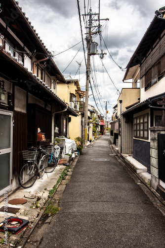 Typical and authentic street in Kyoto  Japan in vertical shot with bicycle in foreground and Japanese traditional architecture