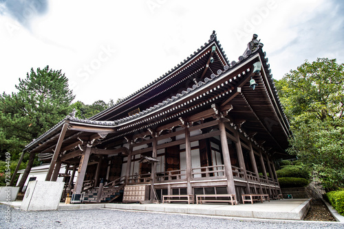 Close-up of a black-and-white temple in Kyoto, Japan, focus effect and mature tree in background, horizontal image. Culture experience in Japan, ancient traditions and historical sites. 