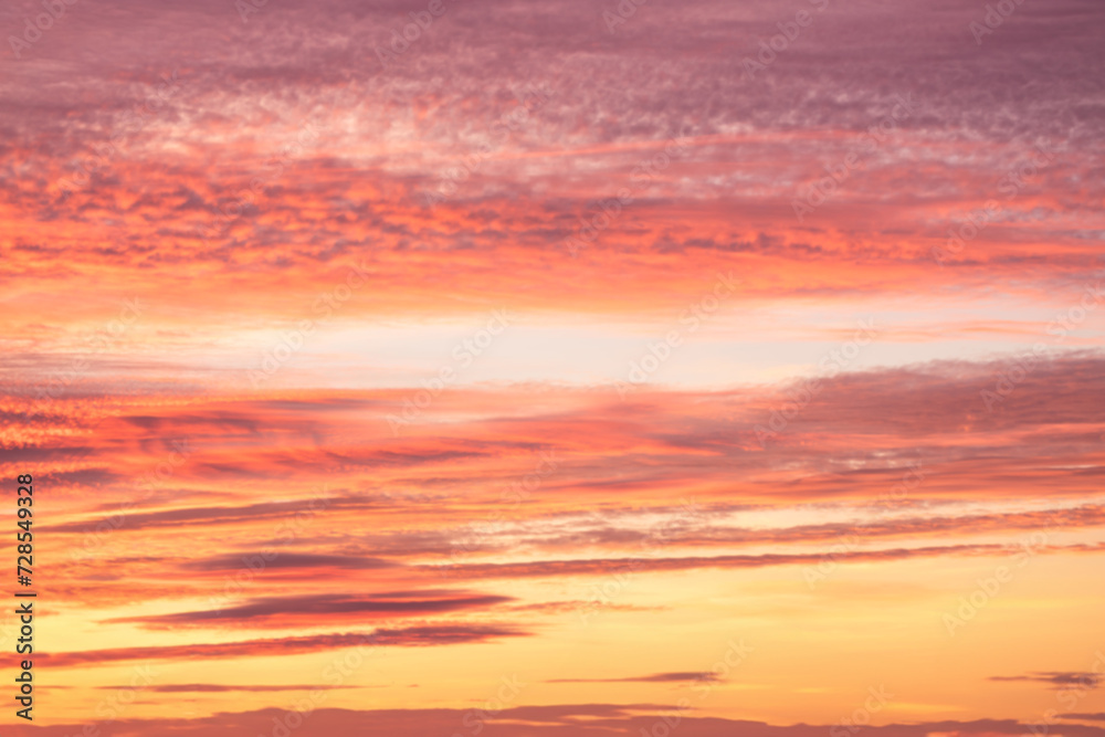 A beautiful sky tinted by the sun leaving vibrant shades of gold, pink, blue and multicolored. Clouds in the twilight evening and morning sky. Cloudy sky background in the evening and during the day.