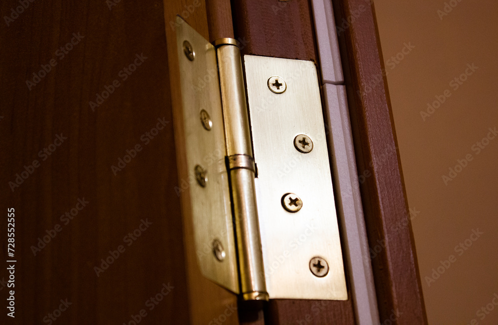 Obraz premium Metal hinge on a wooden entrance door, interior door hinge.