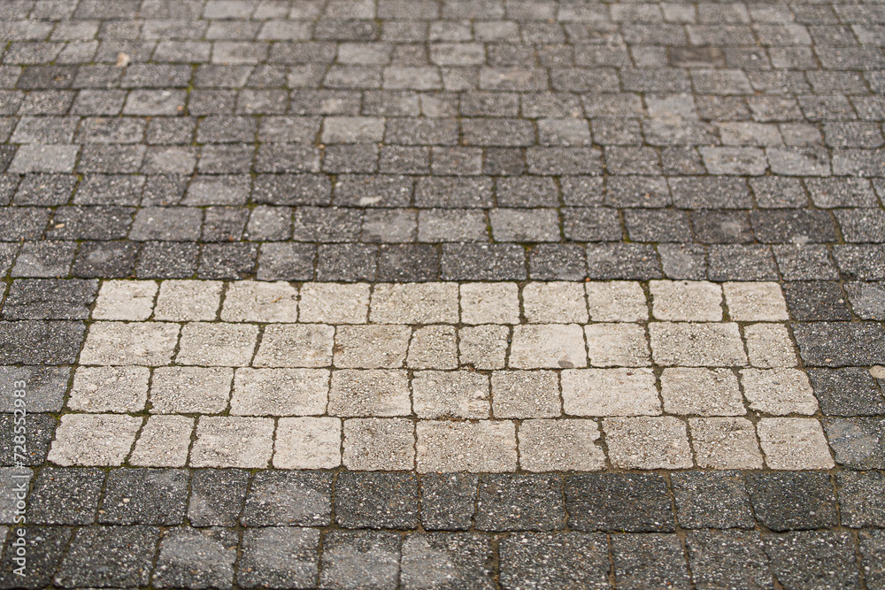 Fototapeta premium The floor is paved with gray stones, top view. stone texture, outdoor stone tiles