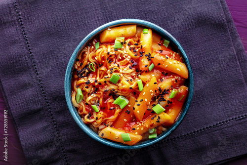 Rabokki, tteokbokki or topokki with ramen, Korean street food, spicy rice cakes in red pepper gochujang sauce, overhead flat lay shot