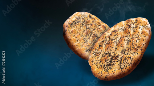 Ramadan pide, concept idea image of two ramadan pide in the air. Dark blue background piping hot traditional Turkish cuisine fresh hot bread. Advertising design. Copy space. Halal islamic food pastry. photo