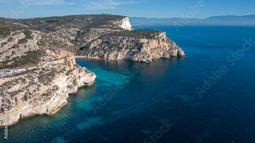 Aerial view with drone of the Sella del Diavolo in Cagliari. Sunny day, crystal clear sea with boats.