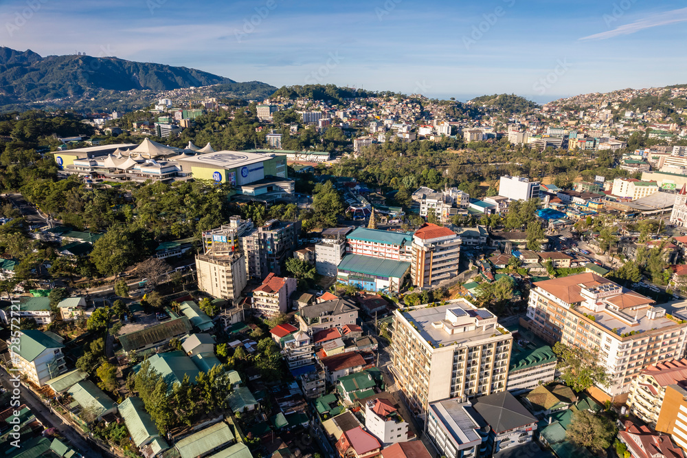 Baguio City, Philippines - Midrise condominiums, schools and SM Baguio dominate the skyline. Aerial of the downtown area.