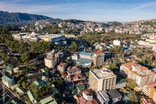 Fototapeta Naklejka Na Ścianę i Meble -  Baguio City, Philippines - Midrise condominiums, schools and SM Baguio dominate the skyline. Aerial of the downtown area.