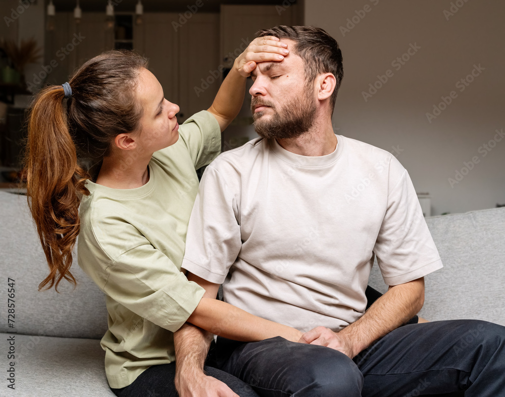 Family care. Wife puts her hand on forehead of her husband measuring temperature with hand. Family care. Wife puts her hand on forehead of her husband measuring temperature with hand.