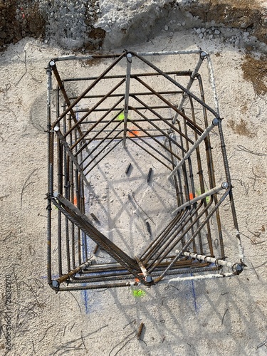 Close up shot from a top angle view of a reinforced column in a construction site on a concrete footing. Process of building a concrete foundation. 