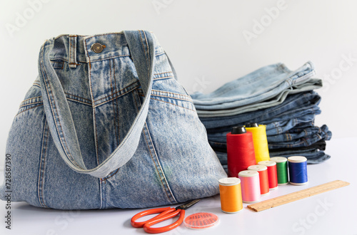 Old jeans and denim bag with sewing accessories, recycling concept, crafting with denim