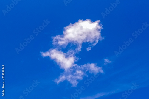A collection of white clouds flying above the clear blue sky