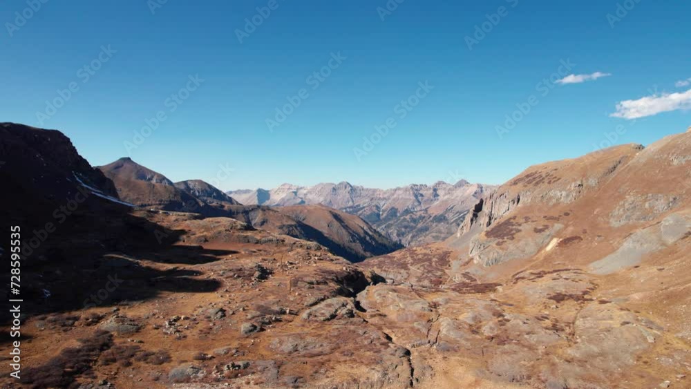 Low drone shot over a mountain valley with a lake and mountain peaks Low drone shot over a mountain valley with a lake and mountain peaks