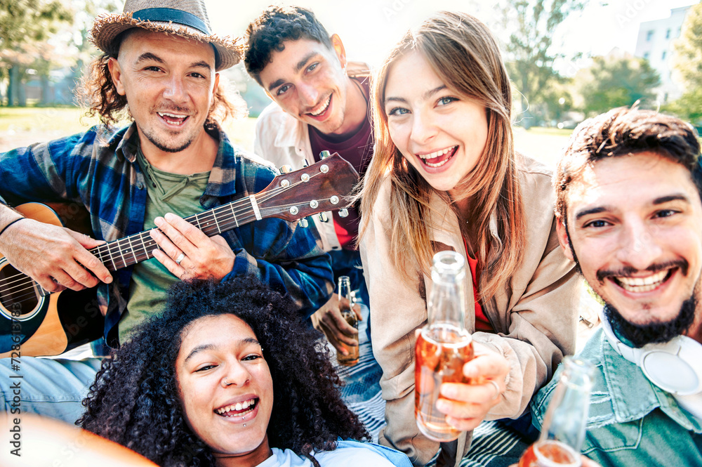 Group of smiling friends having pic-nic in a park on a sunny day - Happy people taking selfie - Life style concept with guys and girls play guitar and relaxing Group of smiling friends having pic-nic in a park on a sunny day - Happy people taking selfie - Life style concept with guys and girls play guitar and relaxing