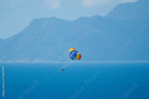 Single person paragliding from boat at beau vallon beach, Mahe, Seychelles  photo