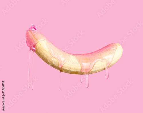 Peeled banana dripping pink gel on pink background.