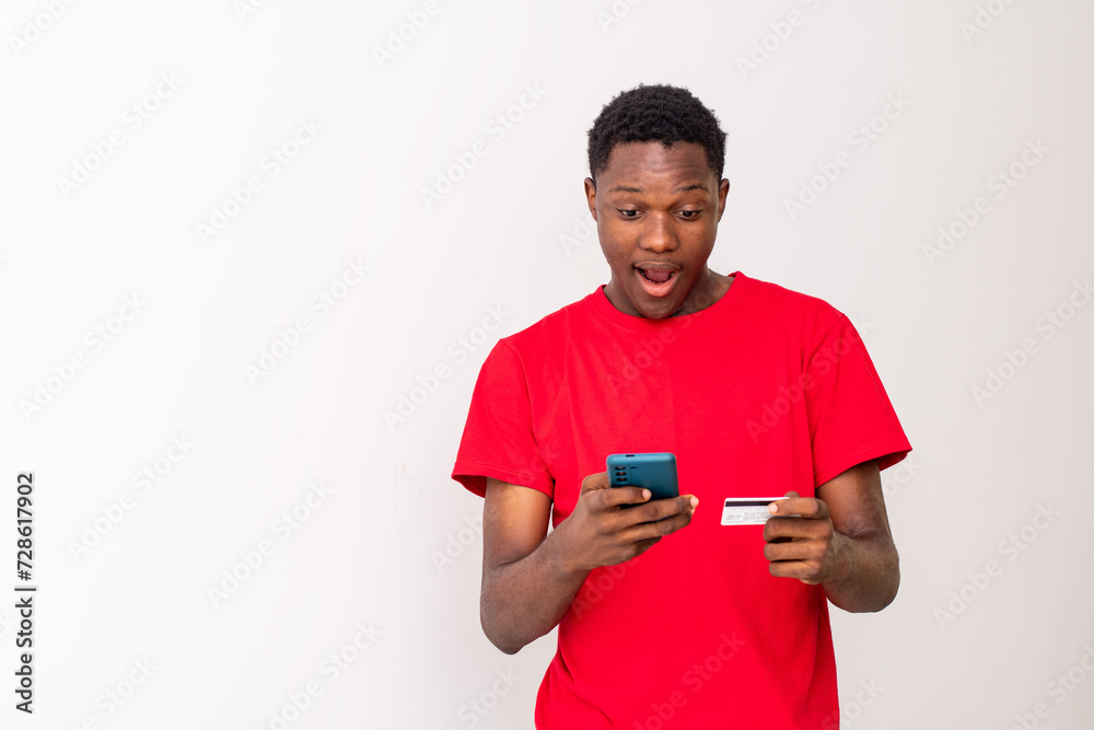 young black man using his phone and credit card young black man using his phone and credit card