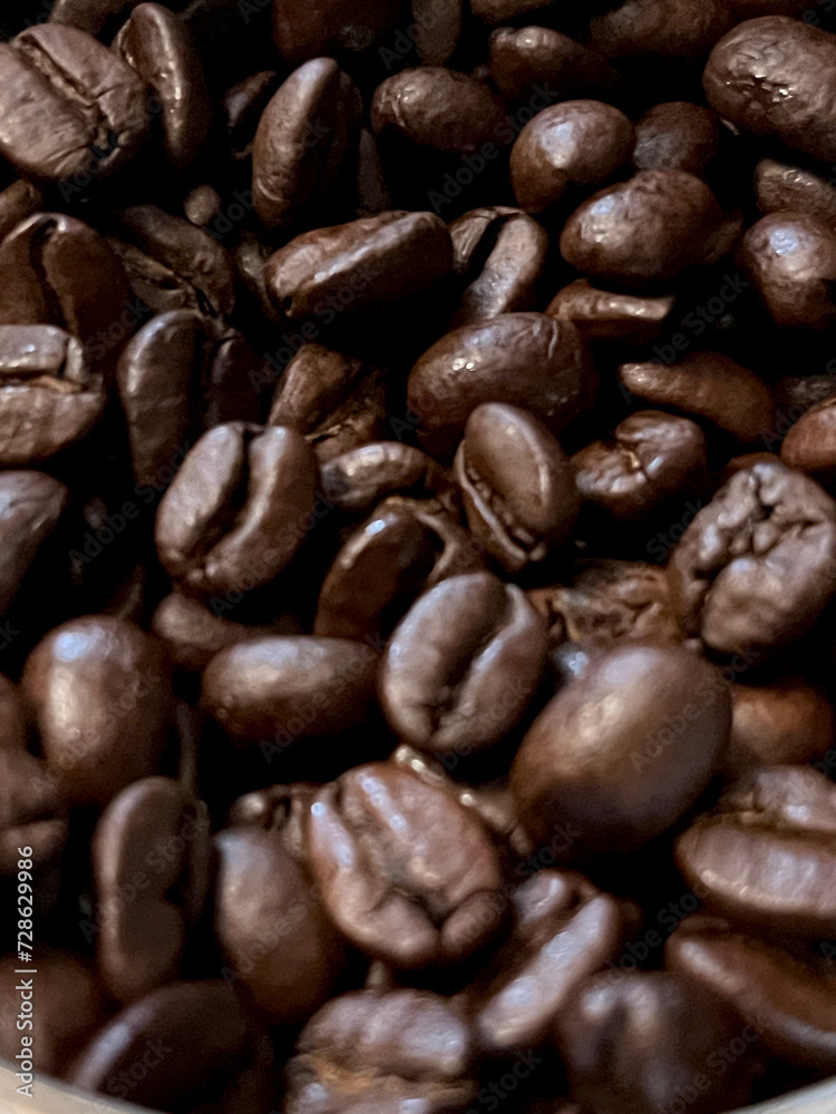 Closeup of glossy coffee beans with selective focus on foreground Closeup of glossy coffee beans with selective focus on foreground
