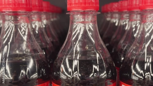 Rows of plastic soda bottles in store or warehouse window.