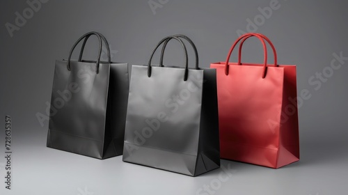3 paper shopping bagd, black and red colors, on solid gray background