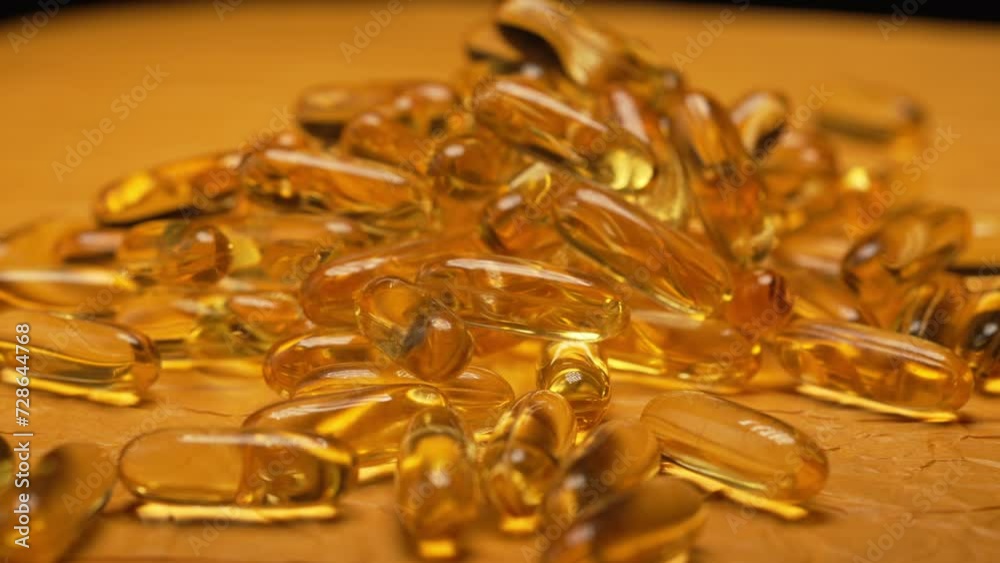 Close-up turntable rotation of gelatin capsules omega 3 fish oil pills background, vitamin E natural capsules texture background Close-up turntable rotation of gelatin capsules omega 3 fish oil pills background, vitamin E natural capsules texture background