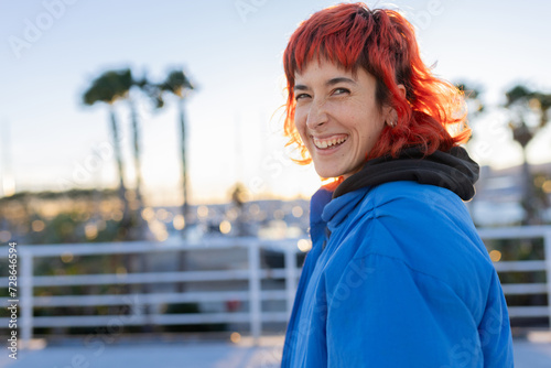 Red Hair Woman Smiling Looking at Camera at Sunset with Blue Jacket
