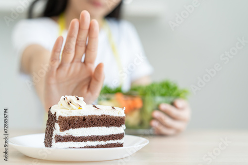 eat less sugar for health, women avoid to eat chocolate cake and sweets during sugar diet session for lose weight photo