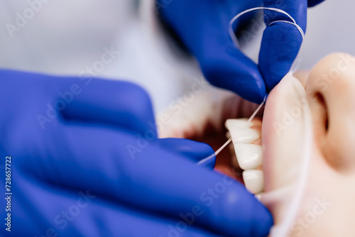 Close-up of flossing teeth. Dentistry, oral hygiene and dental treatment.