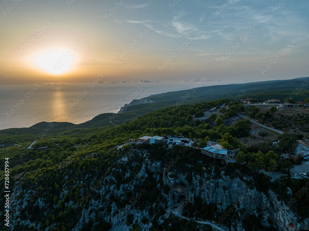Mediterranean sunset from the Agalas viewpoint. Sitting and watching sunset in Zakynthos, Greece. Sunset pine trees, olive groves and sea view on a greek island.