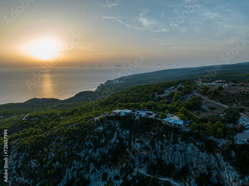 Mediterranean sunset from the Agalas viewpoint. Sitting and watching sunset in Zakynthos, Greece. Sunset pine trees, olive groves and sea view on a greek island. photo