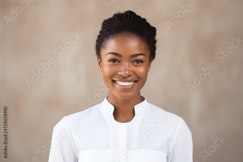 Happy Ghanaian lady with beautiful skin and normal hair, wearing all white, plain background, photo