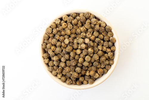 Dry green pepper spice in bowl on a white background.