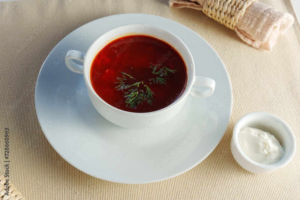 Presented bowl of creamy tomato bisque soup, adorned with a gleaming silver spoon. Presented bowl of creamy tomato bisque soup, adorned with a gleaming silver spoon.