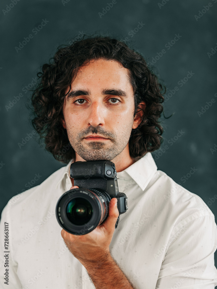 Fototapeta premium young man posing with camera looking confident