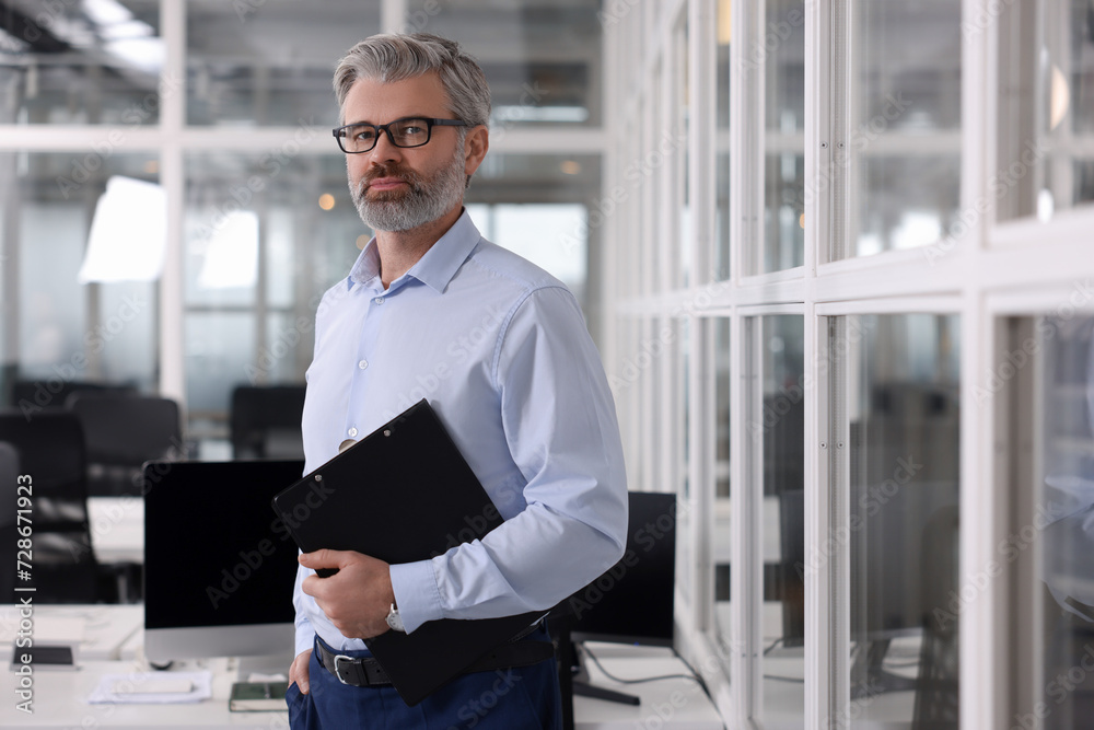 Fototapeta premium Handsome man with clipboard in office. Lawyer, businessman, accountant or manager