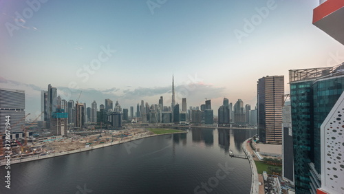 Aerial panorama of Dubai Business Bay and Downtown with the various skyscrapers and towers night to day timelapse