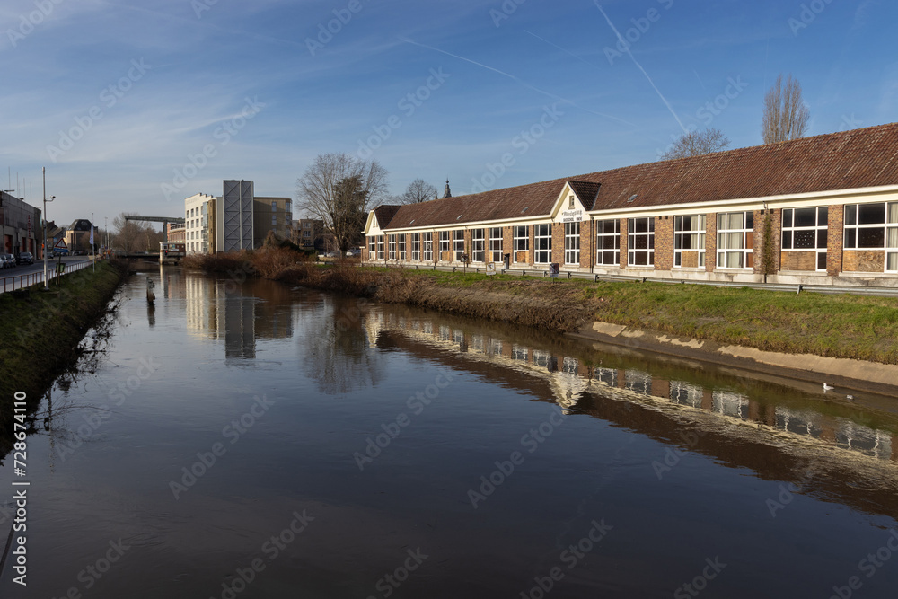View of the River Dender as it flows through the city of Ninove, in East Flanders, Belgium. Copy space below.