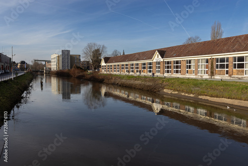 View of the River Dender as it flows through the city of Ninove, in East Flanders, Belgium. Copy space below.