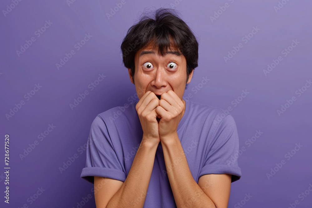 Nervous Asian man and biting nails in studio with oops reaction to gossip on purple background. Mistake, sorry and male overwhelmed by fake news, drama or secret with regret, shame or awkward Nervous Asian man and biting nails in studio with oops reaction to gossip on purple background. Mistake, sorry and male overwhelmed by fake news, drama or secret with regret, shame or awkward
