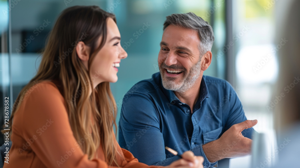 man is smiling at a woman across a table with a laptop in the foreground man is smiling at a woman across a table with a laptop in the foreground