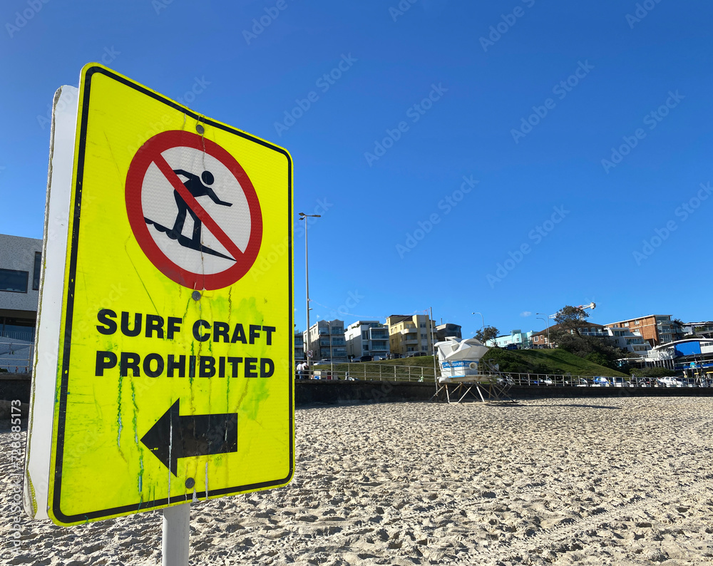 Warning sign on the beach indicating that surf craft is prohibited. Yellow panel to highlight a potential danger in the water.