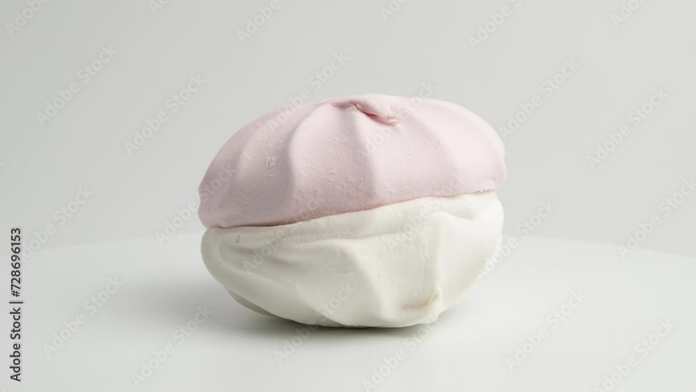 White and pink meringue cookies rotate on a white background. Meringue cookies close-up. White and pink meringue cookies rotate on a white background. Meringue cookies close-up.