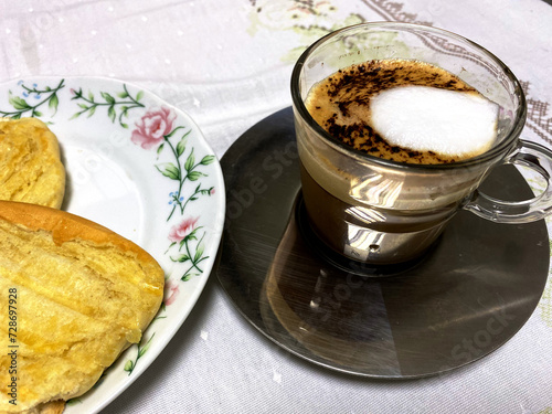 Capuccino coffe cup with tosted bread on the left on a saucer.