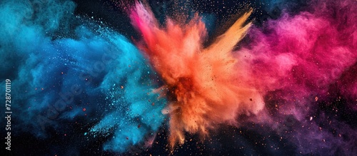 Colored powder explodes on dark surface.