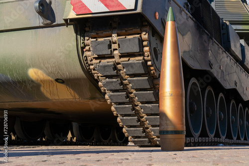 Fotografie A modern camouflage armored self-propelled howitzer with a track from below and